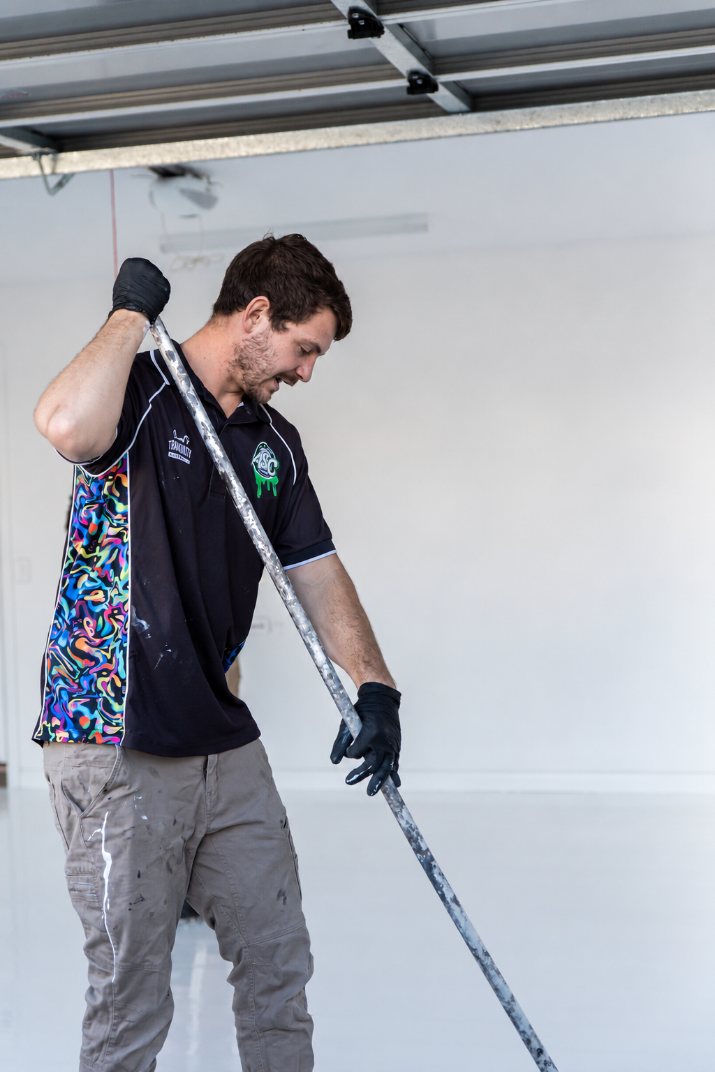 James working on a garage floor with a coating roller